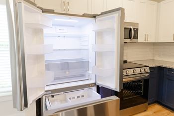 A modern kitchen with a stainless steel refrigerator and oven at The Crest at Oakwood Apartments, Georgia